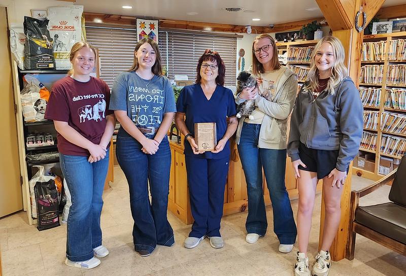 Five adults standing inside a vet office